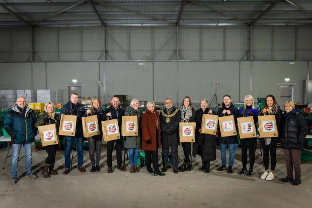 Volunteers stand with Mayor of Bolton after helping to pack food hampers