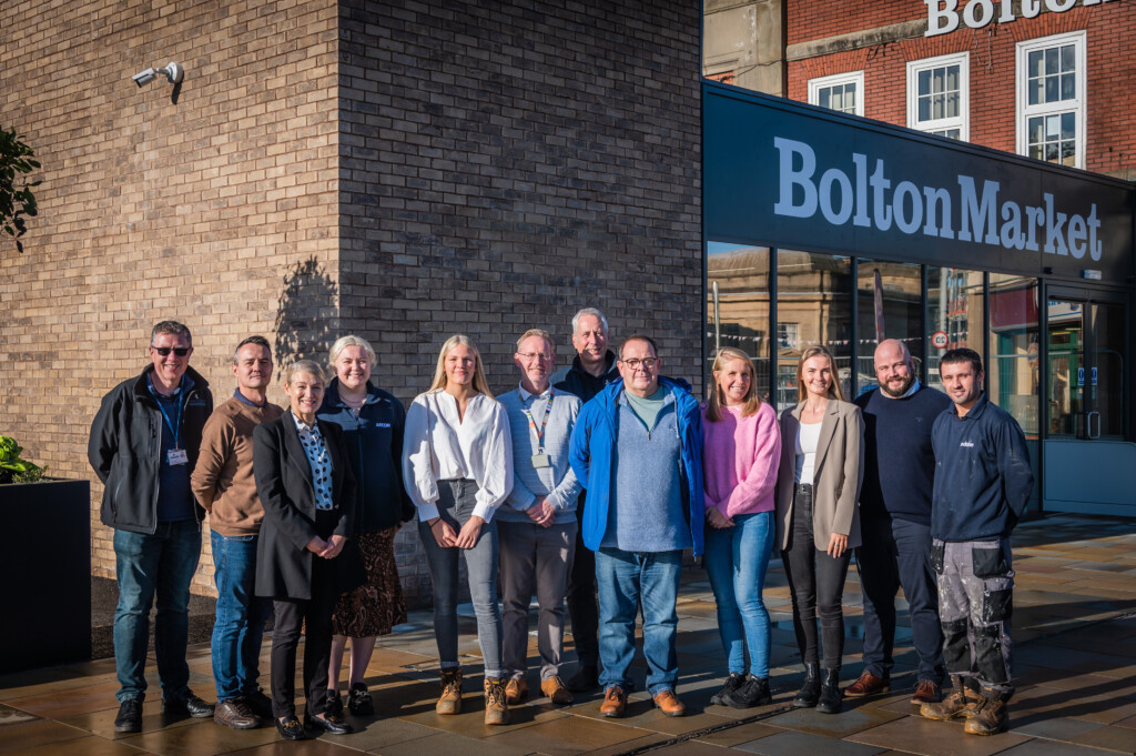 A group of people involved in the extension and refurbishment of Bolton Market pose infront of the completed project